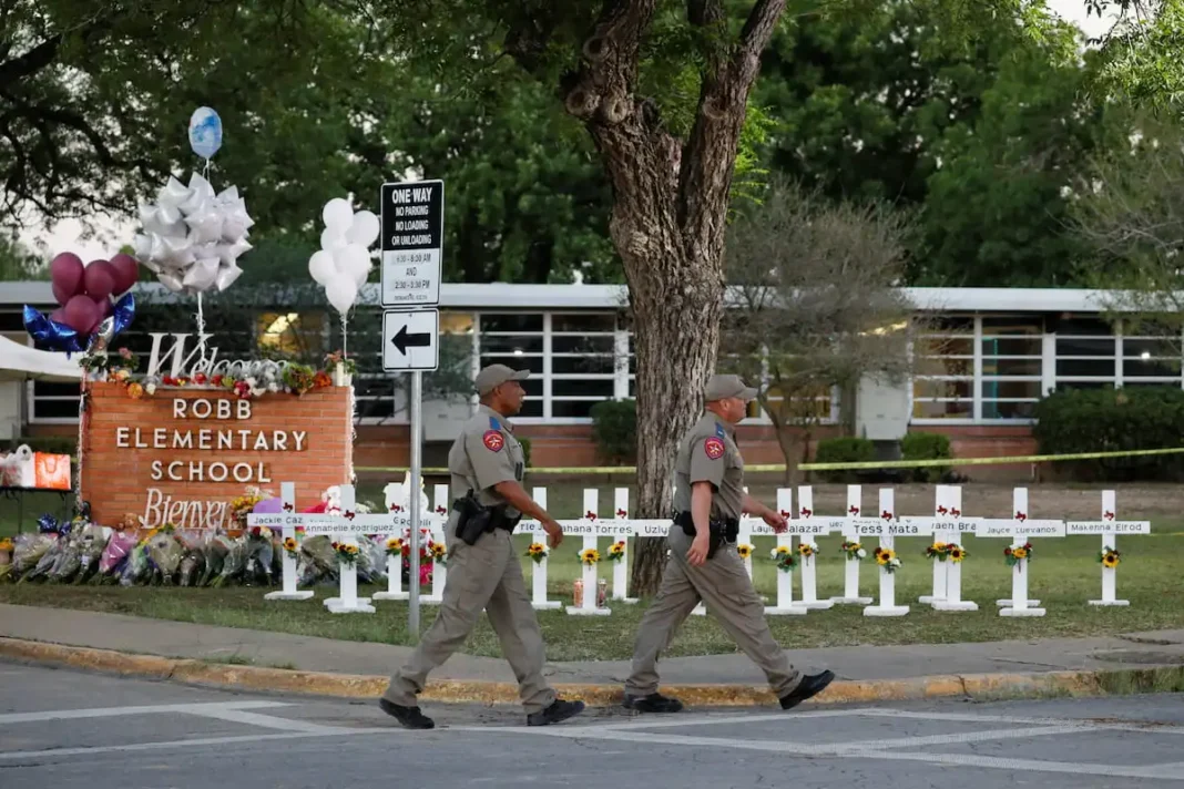 Texas Department of Public Safety officers walk past a memorial outside Robb Elementary school, after a gunman killed nineteen children and two teachers, in Uvalde, Texas, U.S. May 26, 2022. | New Digital Press | ThePeoplesBeat.com | Local Spanish News | Credit: Marco Bello / REUTERS